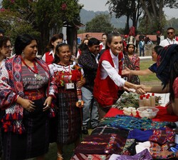 Su Majestad la Reina durante su visita a San José Chacayá se acerca a un puesto para interesarse por los productos expuestos